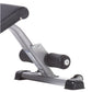 Gray and black compact ab bench with padded seat, adjustable leg extension, and stabilizing feet on white background