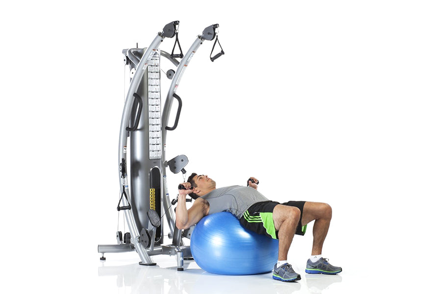 Silver multi-station functional trainer with dual cable systems, adjustable pulleys, and measurement scale, shown with male m