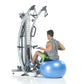 Man using silver dual-cable functional trainer with blue stability ball, demonstrating chest press exercise on white backgrou