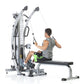 Man using silver and black multi-functional trainer machine with dual cable pulleys and adjustment dial, seated on attached b