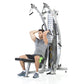 Man using silver and black dual-pulley functional trainer machine with adjustable arms and weight stack, seated on black benc