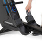 Horizon Oxford 6 black rower with blue accents, shown with model's foot on footrest and hand on console