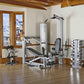 Silver and black multi-station home gym with leg press, chest press, and weight stack on wooden floor in fitness room