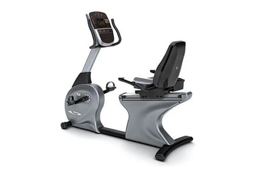 Gray and black commercial recumbent exercise bike with padded seat, handlebar display console, and footrest on white backgrou