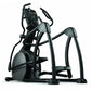 Black and gray elliptical fitness machine with digital console, dual handles, and foot pedals on white background
