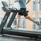 Man running on black Vision T600 treadmill with digital display in gym studio with windows