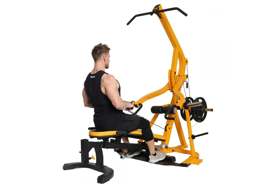 Yellow and black multi-function home gym machine with lever arms, used by model in black tank top on white background