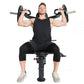 Male athlete seated on black weight bench performing dumbbell shoulder press with weighted barbells, wearing black sleeveless