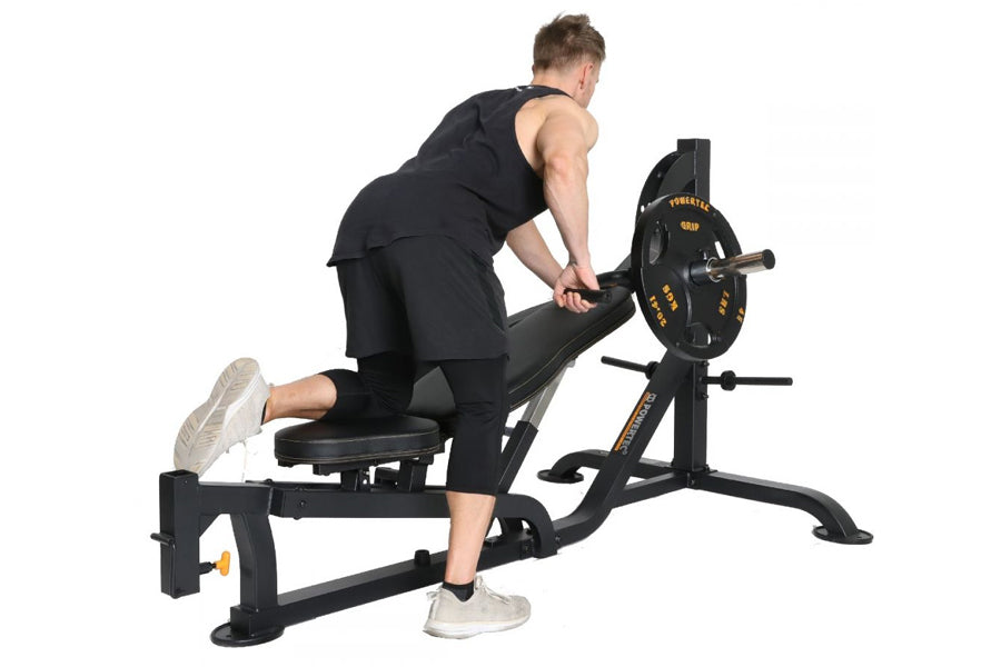 Man using black Powertec WorkBench MultiPress home gym equipment with weighted plate, shown from side angle on white backgrou