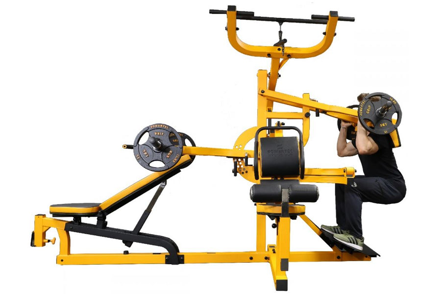 Yellow and black multisystem home gym with weight plates, leg press station, and chest press machine, demonstrated by user in