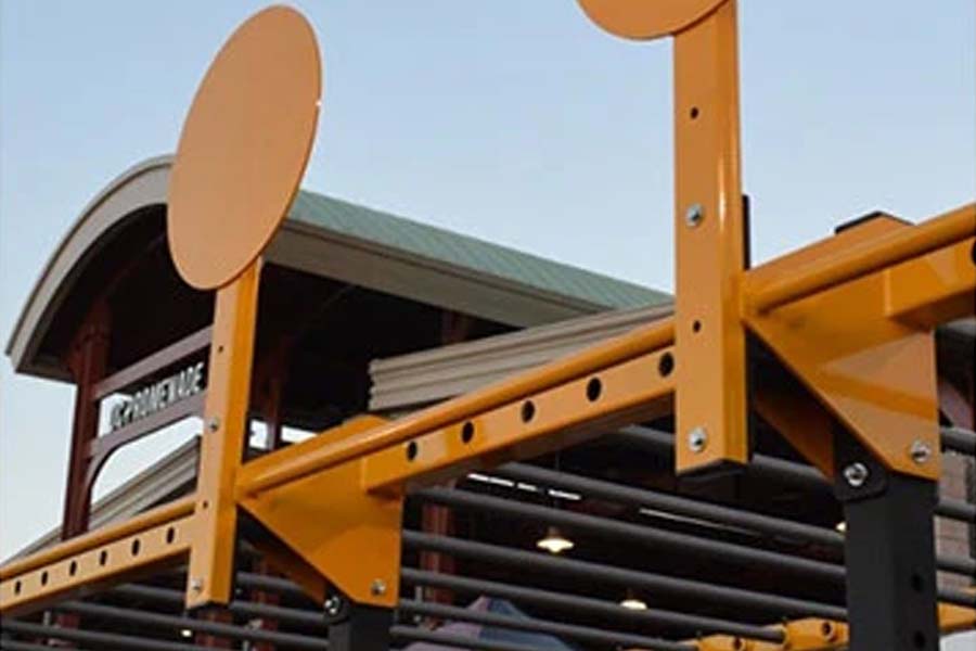 Yellow steel wall ball target attachment with round impact plate, mounted on orange support frame