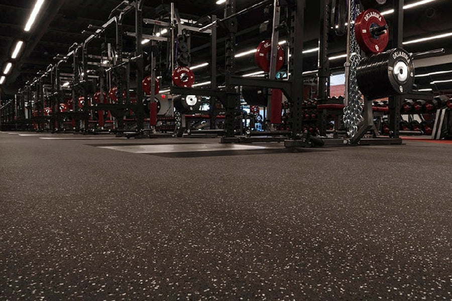 Warrior Multilayer Interlocking Rubber Gym Flooring Tiles in cedar color installed in fitness facility with weight racks and 