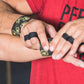 Black and gold athletic tape worn on fingers and wrist by model in red shirt
