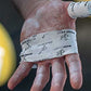 White athletic tape with black printed pattern wrapped around hand and finger, worn during activity