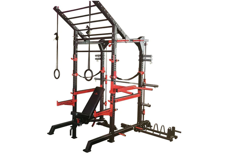 Black and red steel power cage with integrated bench, pull-up bars, and weight plate storage on white background