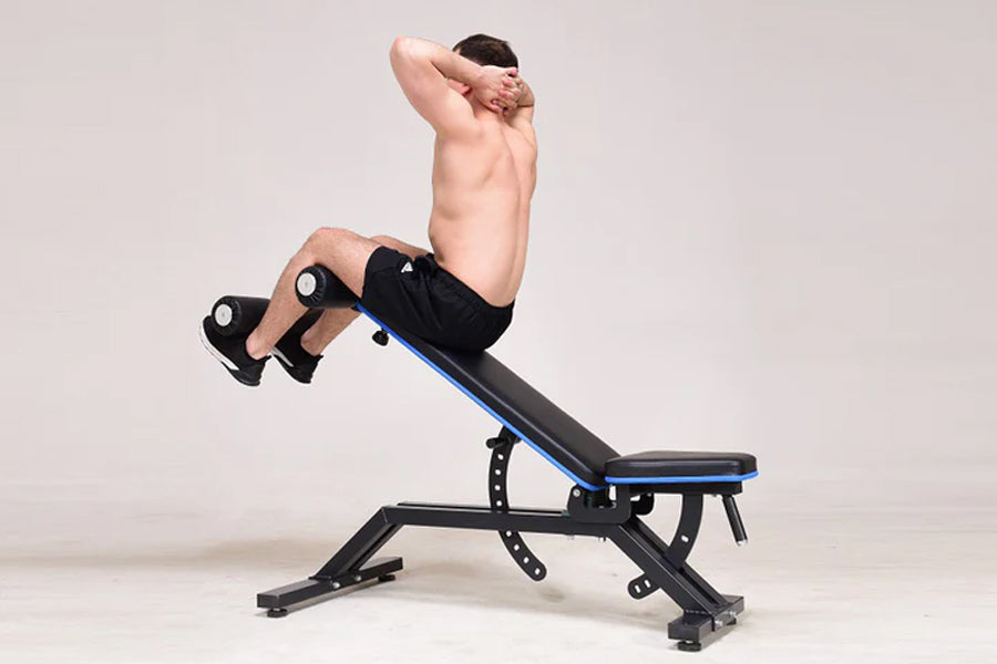 Man performing decline sit-up on black and blue adjustable weight bench against white background