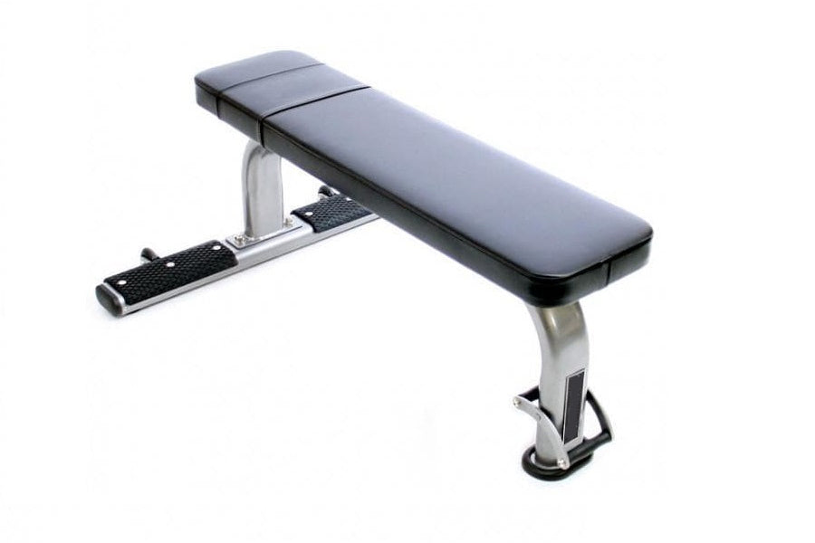 Warrior Commercial Flat Bench with gray padded seat, silver metal frame, and black textured footrest on white background