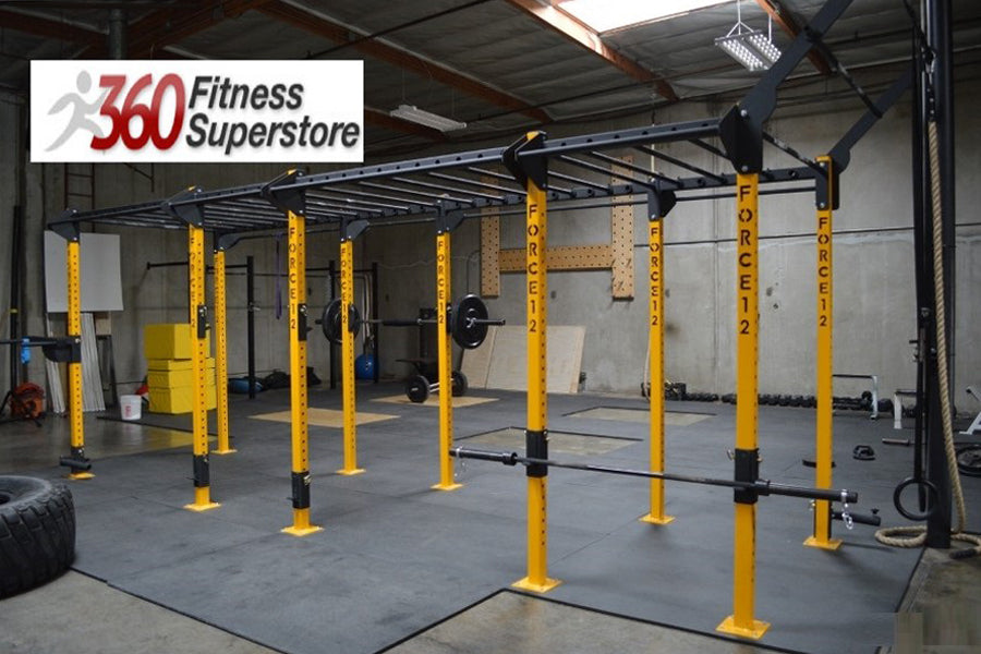 Warrior Commercial Pro Rig System with yellow posts and black horizontal bars in gym setting on gray flooring