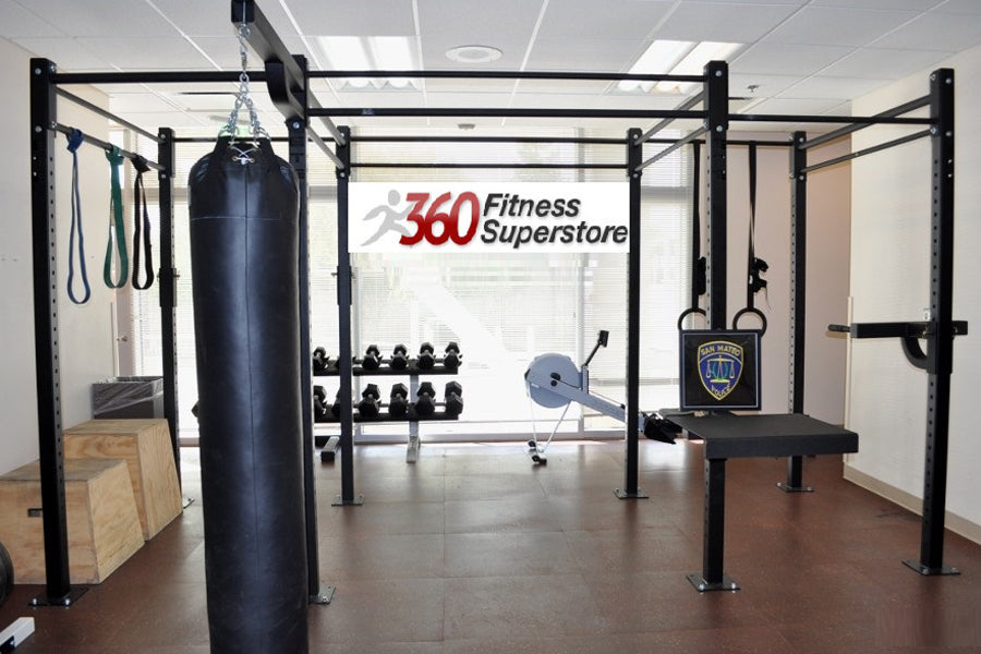 Black multi-functional crossfit rig system with pull-up bars, heavy bag hanging attachment, and training accessories in fitne