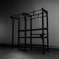 Black steel functional training rig with pull-up bars, weight plate storage, and adjustable chin-up station on gray backgroun