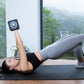 Woman performing dumbbell chest press on black exercise mat wearing gray leggings with stripe detail and black sports bra, ho