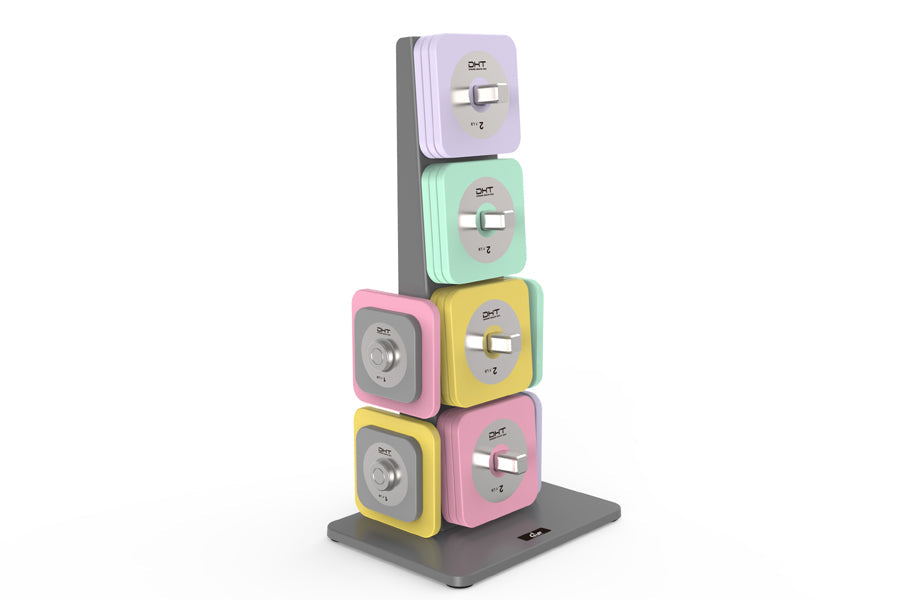 Stacked modular dumbbells in pastel colors including purple, mint green, pink, and yellow with silver switches on dark gray b