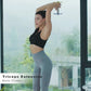 Woman performing triceps extension with adjustable dumbbell, wearing black sports bra and gray leggings, by bright window wit