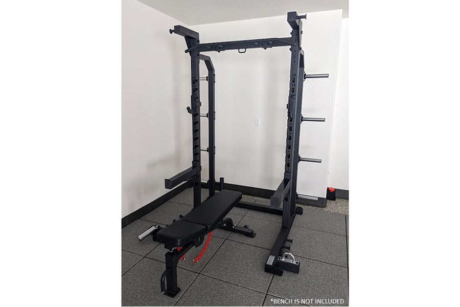 Black power cage squat rack with pull-up bar and weight plate storage pegs, shown on gym flooring without bench