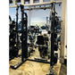 Black power squat rack with adjustable safety bars and J-hooks in gym setting