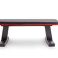 Black and red flat weight bench with padded seat, sturdy black metal base, on white background