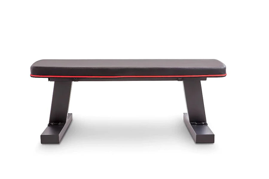 Black and red flat weight bench with padded seat, sturdy black metal base, on white background