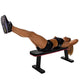 Woman performing leg raise exercise on black flat bench with red trim against white background