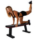 Woman performing leg lift exercise on black and red flat weight bench with dumbbells