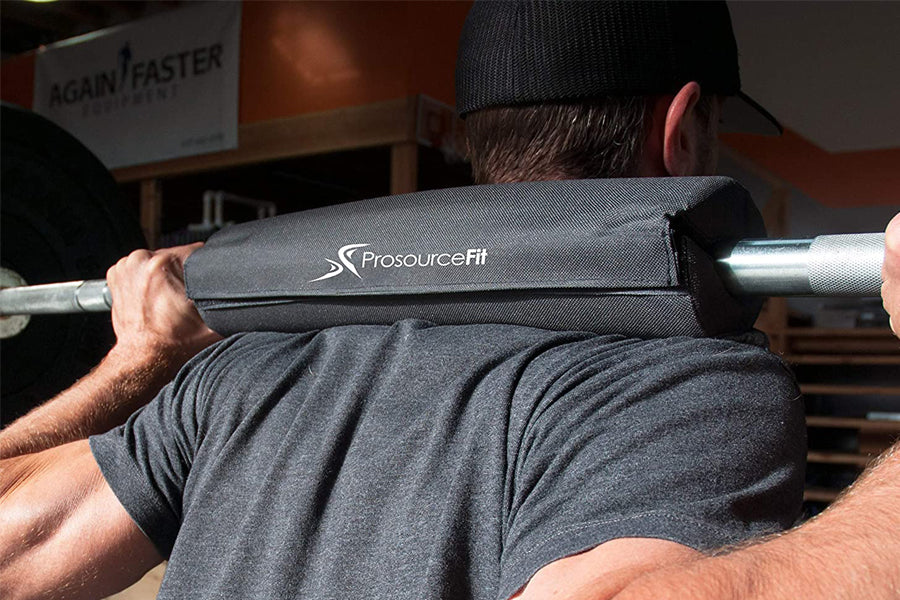 Black foam barbell pad with silver metal bar worn by male model during squat exercise