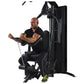 Man using black Warrior HG500 home gym with leg press and chain attachment, seated position on white background