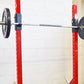 Warrior Heavy Duty Individual Squat Stands with red uprights, black weight plates, and metal bar, mounted on white brick wall