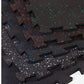 Black interlocking rubber gym floor tile with white, blue, orange and green speckles, shown in flat lay view