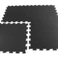 Black interlocking rubber gym flooring tiles with speckled texture and puzzle-piece edges on white background