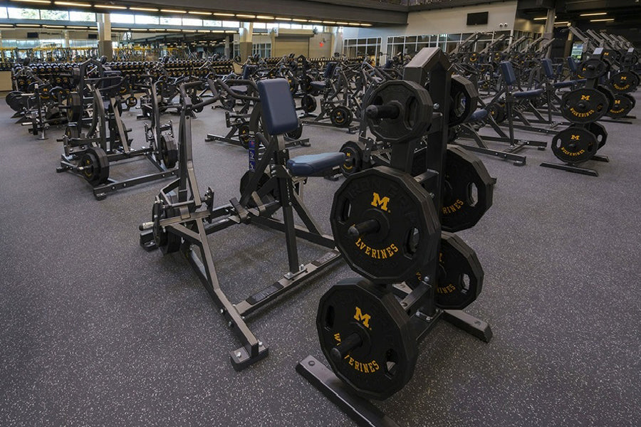 Warrior Interlocking Rubber Gym Flooring Tiles in speckled gray, installed in fitness facility with exercise equipment