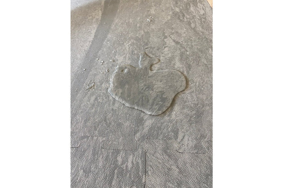 Wet footprint on grey interlocking marble gym tile flooring in gunmetal tone