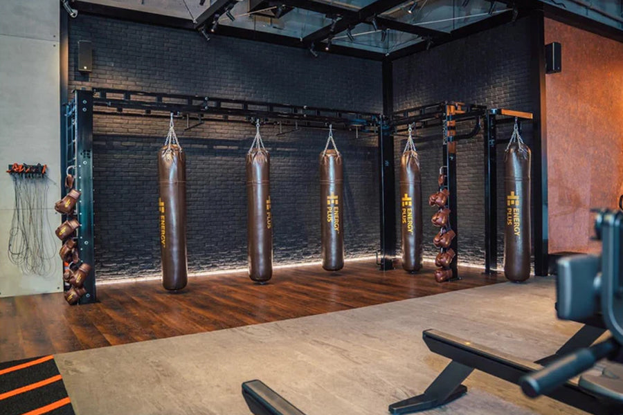 Gunmetal grey interlocking gym tiles installed in boxing studio with heavy bags and brick walls