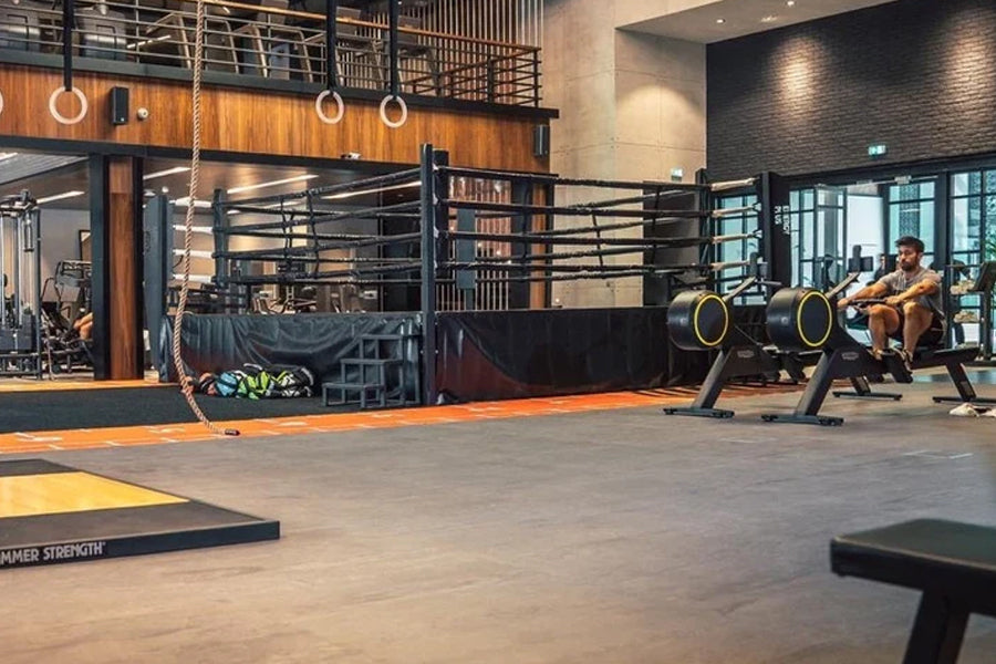 Warrior Marble Interlocking Gym Tile Flooring in pine installed in modern fitness studio with training equipment and black ra