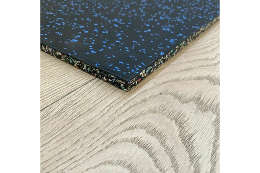 Warrior Multilayer Interlocking Rubber Gym Flooring Tile with black speckled surface and tan edge binding, displayed on light