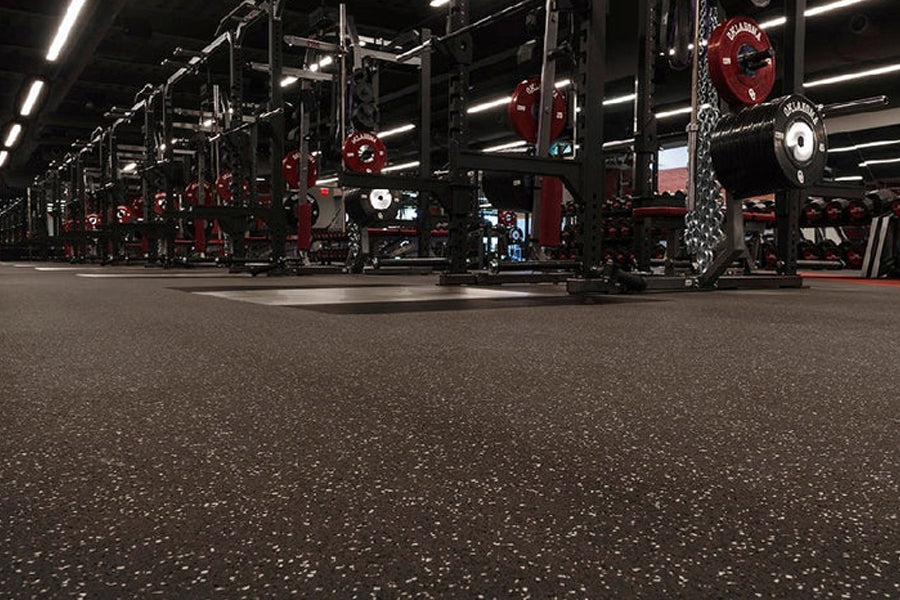 Warrior Multilayer Interlocking Rubber Gym Flooring Tiles in black with red speckle, installed in commercial gym with weightl