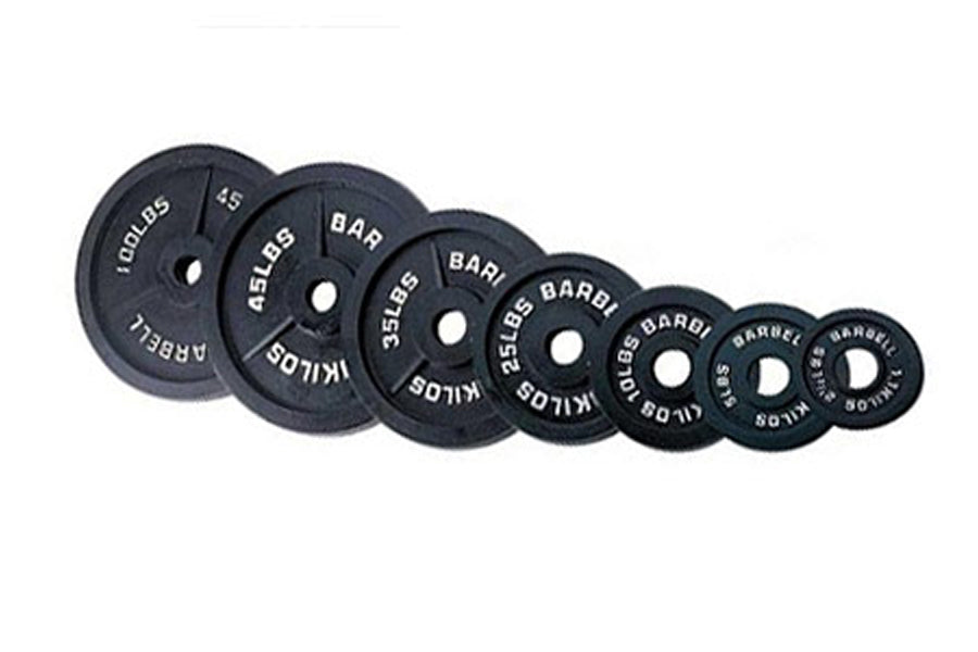 Warrior brand Olympic cast iron weight plates in graduating sizes from 45 lbs to 2.5 lbs, arranged in descending order on whi