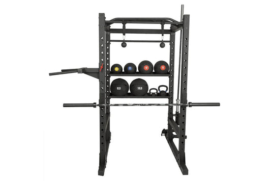 Black power rack with weight plate storage shelves holding colored medicine balls and dumbbells, featuring pull-up bar and ba