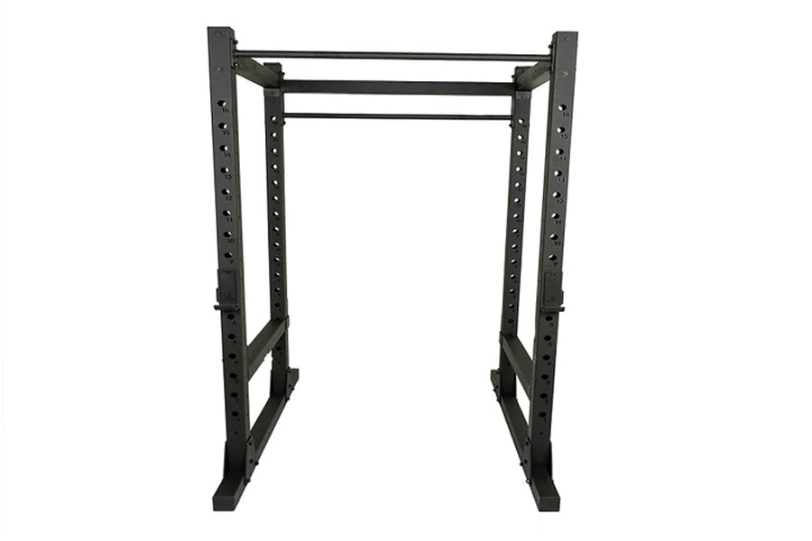 Black steel power rack with perforated uprights, adjustable cross bars, and foot plates on white background