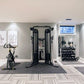 Warrior rubber gym floor mats in charcoal gray, shown installed in modern home gym with exercise equipment on light wood-look
