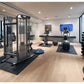 Modern home gym interior with light wood flooring, featuring Warrior Rubber Gym Floor Mats in black under exercise equipment 