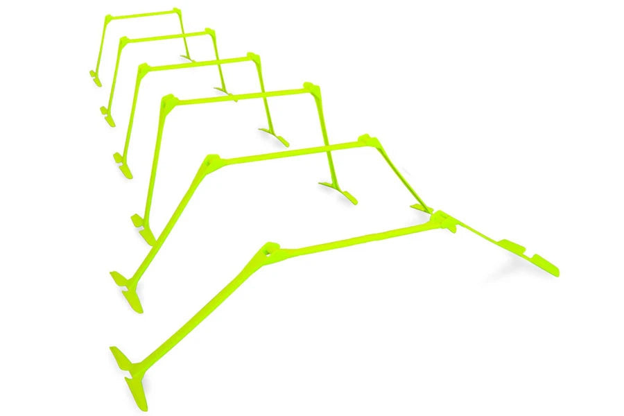 Set of five neon yellow adjustable folding speed hurdles with extending legs, displayed in descending size order on white bac